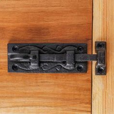 an iron latch on a wooden door