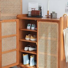 an open cabinet with shoes and umbrellas on the top shelf in front of it