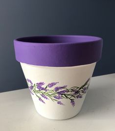 a purple and white flower pot sitting on top of a table