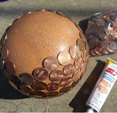 a close up of a ball with coins on it and a tube of glue next to it