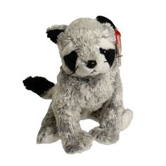 a small stuffed racoon is sitting on the floor with its headphones up