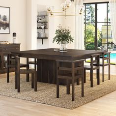 a dining room table with chairs and a potted plant on top of the table