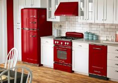 a red stove top oven sitting inside of a kitchen next to a refrigerator freezer