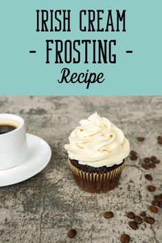 a cupcake with cream frosting sitting next to a cup of coffee on a table