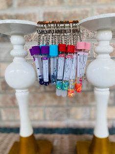 several tubes are hanging from a chandelier in front of a brick wall