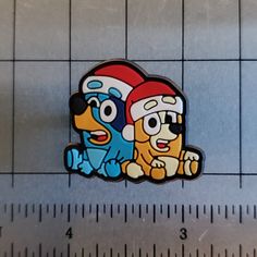 two cartoon characters sitting on top of each other next to a ruler