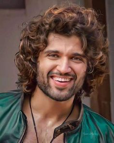 a close up of a person wearing a leather jacket and smiling at the camera with long curly hair