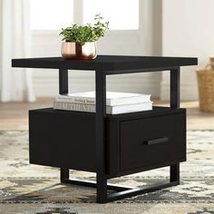 a black end table with two drawers and a potted plant on top