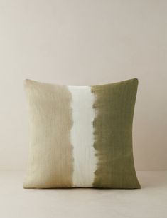 a green and white pillow sitting on top of a table