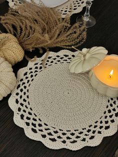 crocheted doily with a lit candle on it and some yarn next to it