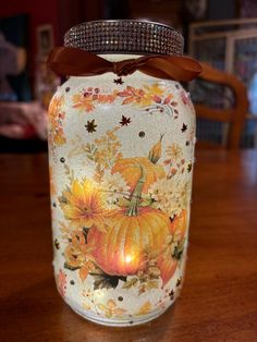 a decorated glass jar with a candle in it