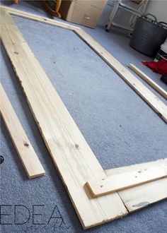 two pieces of wood are laying on the floor in front of a blue carpeted room