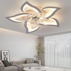 a living room filled with furniture and a large flower light fixture above the coffee table