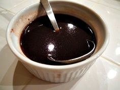 a spoon in a cup filled with dark liquid