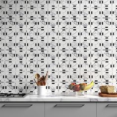 a kitchen counter with some fruit on top of it and a wall paper behind it