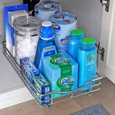 a kitchen sink filled with lots of cleaning supplies and detergent on top of it