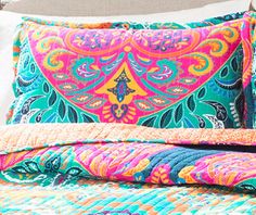 a bed with colorful bedspread and pillows