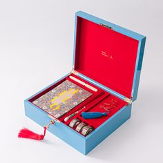 an open blue box with red items in it and a tassel hanging from the inside