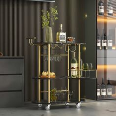 a gold bar cart with bottles and glasses on it in front of a striped wall