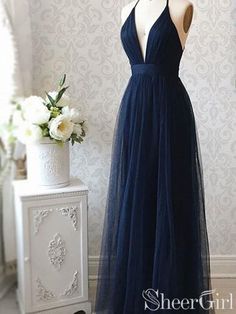 a dress that is on display in front of a white table and vase with flowers