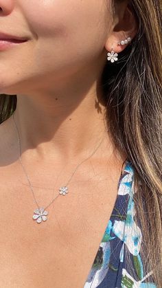 "Bring the beauty of springtime to your everyday looks with this dainty diamond daisy necklace. Set along an elegant cable chain, the flowers in this piece give off just the right amount of sparkle. -14K gold weighing 3.48 grams -144 round single cut diamonds totaling 0.34 carats are pave-set -2 round full cut diamonds totaling .05 carats - G-H in color and SI1-SI2 in clarity. - Available in rose, yellow, & white gold. Item no. N10322 The large daisy measures about 15 millimeters wide by 15 Flower Shaped Diamond Necklace For Gift, Delicate White Gold Flower Pendant Necklace, Fine Jewelry Flower Pendant Necklace, Diamond Flower Necklace, Nameplate Necklace Gold, Flower Necklace Gold, Large Daisy, Diamond Monogram, Diamond Bar Necklace