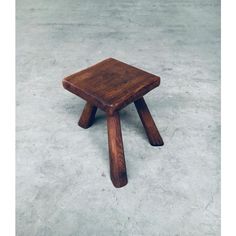 a small wooden stool sitting on top of cement