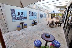 an outdoor patio area with tables and umbrellas