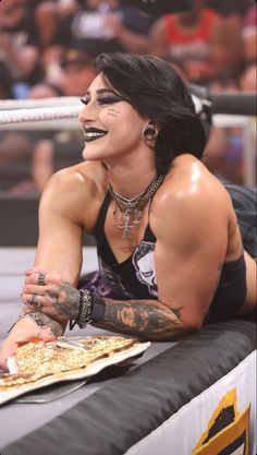 a woman with face paint laying on top of a wrestling ring