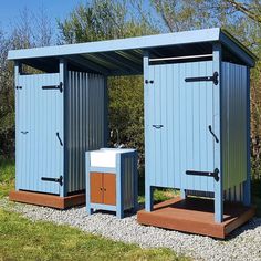 two blue portable toilets sitting next to each other on top of a grass covered field