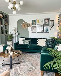 a living room with green couches and pictures on the wall