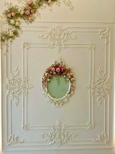 the wall is decorated with flowers and an oval mirror on it's side,