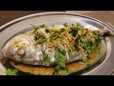 a silver plate topped with fish covered in toppings