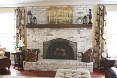 a living room filled with furniture and a fire place in front of a brick fireplace