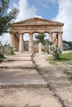 an old stone structure with steps leading up to it and cactus trees in the background