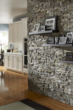 a stone wall in a kitchen with pictures on it