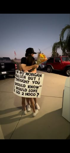 two people hugging each other while holding signs in front of them that read, no morgan i'm a bit too though you should know