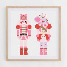 two cross - stitch nutcrackers in pink and white are standing next to each other