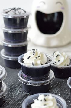 there are many small cups that have whipped cream in them and sprinkled with black dots