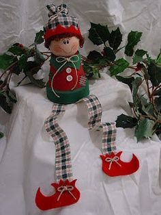 a christmas decoration is displayed on a table with holly branches and ivys in the background