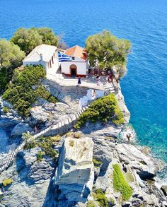 an aerial view of a house on the edge of a cliff by the ocean with stairs leading up to it