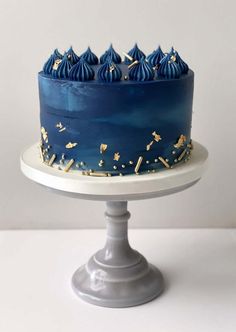 a blue cake with gold sprinkles on top