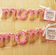 two packaged donuts with pink frosting and sprinkles are on display