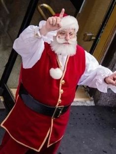 a man dressed as santa clause pointing at the camera