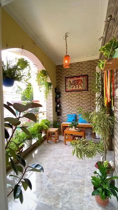 an outdoor patio with potted plants on the wall and tables in the center area