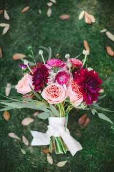 a bouquet of flowers sitting on top of a lush green field