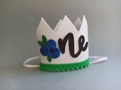 White birthday crown with blueberry for your baby's 1st birthday party! A must-have for any berry birthday party or photoshoot! Crowns are attached to a white elastic headband and meant to be worn around the back of the head, behind the ears (not under chin. Сrown size: height 2,56 inch (6,5 сm)and width 2,56 inch (6,5 cm) Please contact me if you have any questions regarding color of crown or regarding the number indicating the age and if you wish I will create a similar product but in the colo Cute Birthday Crown With Round Shape, Adjustable Round Crown For Birthday, Blueberry First Birthday, Berry Birthday, First Birthday Hat, First Birthday Hats, White Birthday, Baby 1st Birthday, Birthday Crown