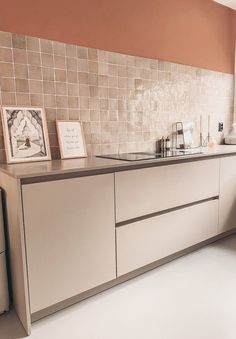 a kitchen area with sink, refrigerator and dishwasher next to window on tiled wall