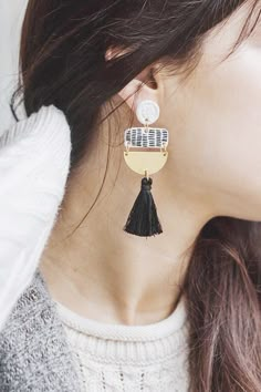 a close up of a person wearing some kind of earring with tassels