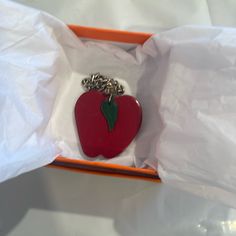 an apple shaped keychain is in a box