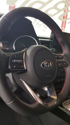 the inside of a car with steering wheel and gauges on display in a showroom